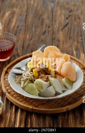 Kupat Tahu, colazione tipica da Giava Ovest, Indonesia. Torta di riso compressa servita con tofu giallo, germogli e salsa piccante di arachidi Foto Stock