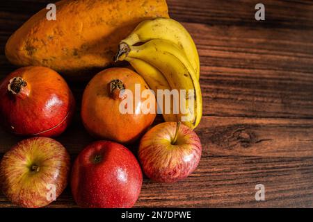 Molte varietà di frutta disposte su un tavolo di legno con spazio copia Foto Stock