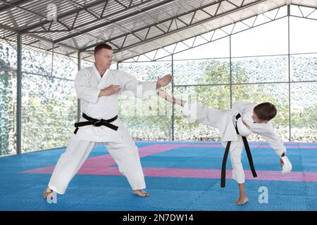 CHERNOMORKA, UCRAINA - 10 LUGLIO 2020: Bambino con istruttore di karate in campo di allenamento Foto Stock