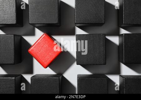 Cubo rosso tra gli altri su sfondo bianco, piatto Foto Stock