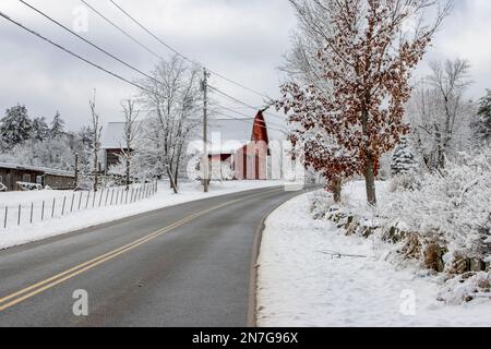 Un vecchio fienile rosso coperto di neve a Royalston, Massachusetts Foto Stock