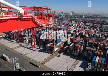 I container impilati aspettano di muoversi con gru automatiche (ASC) presso il cantiere del Terminal container di Long Beach (LBCT) nel porto di Long Beach. L'investimento di $2,5 miliardi di LBCT che ha consentito a uno dei principali operatori portuali di ridurre in modo significativo le emissioni e di avere "zero netto" alla portata di tutti. Questo tour rivelerà anche per la prima volta ulteriori dettagli su un progetto da $30 milioni di dollari realizzato presso la LBCT per implementare attrezzature per la movimentazione del carico a emissioni zero e uno sguardo esclusivo ai piani della LBCT di decarbonizzare completamente le operazioni entro il 2030. Foto Stock