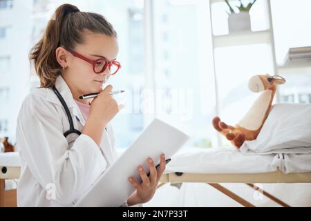 Lascia correre la tua immaginazione. una bambina che finge di essere un medico mentre esamina il suo animale farcito a casa. Foto Stock