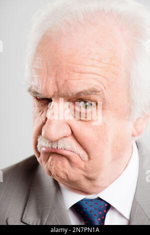 Ive ha avuto il mio occhio su di te. un uomo anziano in piedi da solo nello studio e che guarda scettico. Foto Stock