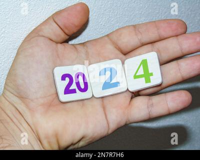 L'anno 2024 sta per arrivare. Una persona tiene numeri che formano l'anno 2024 nel suo palmo Foto Stock