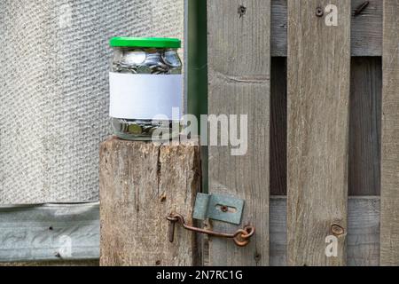 Barattolo con monete ucraine e un'etichetta bianca con posto per i supporti di testo Foto Stock