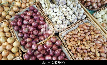 mix di cipolla bulbo in vendita cestini al banco del mercato Foto Stock