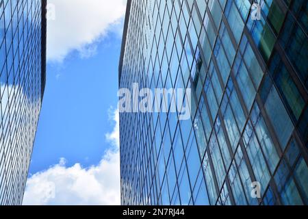 Vista dal basso dei grattacieli moderni nel quartiere degli affari, con il cielo blu. Guardando in alto gli edifici commerciali nel centro città. Foto Stock