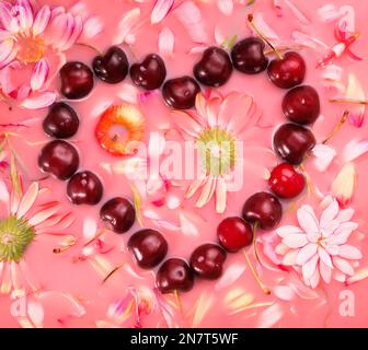 a forma di cuore dolce ciliegio modello e fiori in acqua rosa, piatto Foto Stock