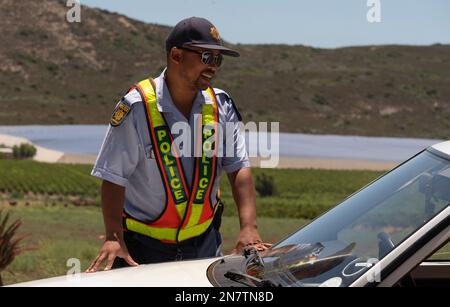 Western Cape, Sudafrica, 2023 SAPS ufficiale di polizia sudafricano su una patente di guida su strada e controllo assicurativo Foto Stock