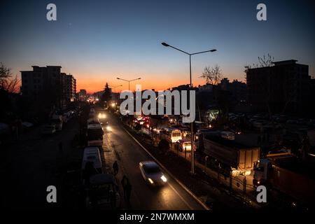 Traffico nel centro della città e il relitto degli edifici distrutti visti durante il tramonto. Lunedì mattina, una forte magnitudine 7,7, centrata nel distretto di Pazarcik, jolted Kahramanmaras e fortemente scosso diverse province, tra cui Gaziantep, Sanliurfa, Diyarbakir, Adana, Adiyaman, Malatya, Osmaniye, Hatay e Kilis. Più tardi, alle 13,24 (1024GMT), un terremoto di magnitudo 7,6 centrato nel distretto di Kahramanmaras' Elbistan colpì la regione. Turkiye ha dichiarato 7 giorni di lutto nazionale dopo terremoti mortali nelle province meridionali. Foto Stock