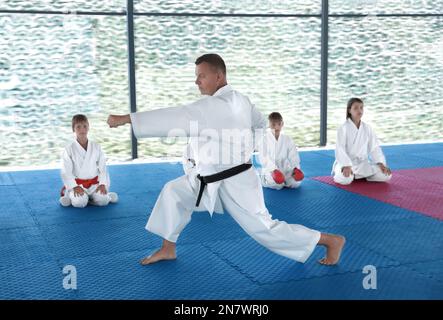 CHERNOMORKA, UCRAINA - 10 LUGLIO 2020: Istruttore di Karate con bambini in campo formativo Foto Stock