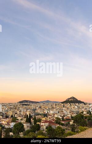 Vista dalla collina del sito dell'Acropoli in una serata di sole durante il tramonto ad Atene in Grecia Foto Stock