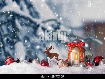 Lanterna di Natale decorata con candela bruciante all'aperto Foto Stock