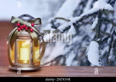 Lanterna di Natale decorata con candela bruciante all'aperto, spazio per il testo Foto Stock