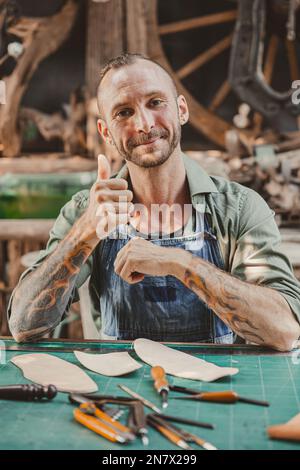 ritratto felice artista cuoio artigianale lavoro in proprio laboratorio piccolo studio realizzato su ordinazione pezzo da masterwork Foto Stock