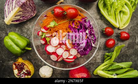 ciotola in vetro per insalate fresche con vista ad angolo alto circondata da frutta di verdura Foto Stock