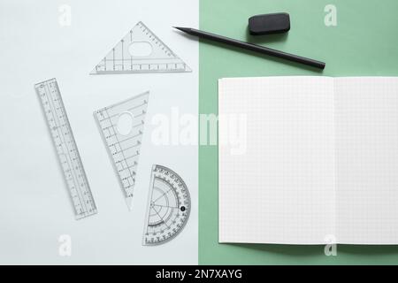 vista rialzata attrezzatura geometrica notebook gomma matita doppio sfondo colorato Foto Stock