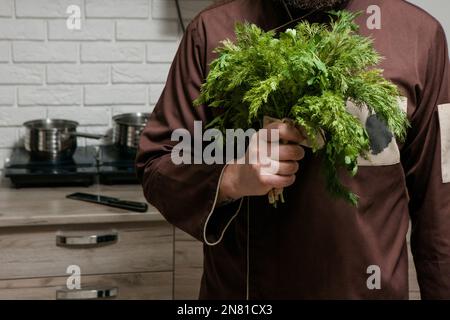 Chef con bouquet di prezzemolo e aneto in cucina Foto Stock