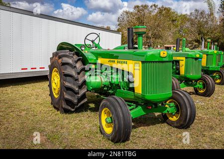 Fort Meade, FL - 22 febbraio 2022: Vista dall'alto in prospettiva dell'angolo anteriore di un trattore speciale per riso John Deere 830 del 1959 in occasione di una fiera locale dei trattori. Foto Stock