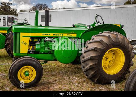 Fort Meade, FL - 22 febbraio 2022: Vista laterale in prospettiva alta di un trattore speciale per riso John Deere 830 del 1959 in occasione di una fiera automobilistica locale. Foto Stock