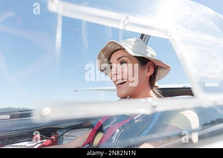 bella giovane donna seduta all'interno di un piccolo aereo Foto Stock