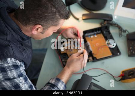 tecnico che ripara un telefono Foto Stock