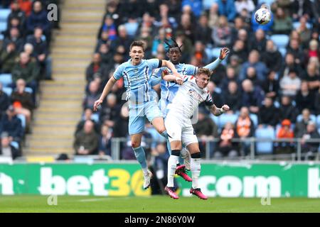 Callum Doyle (a sinistra) di Coventry City e Josh Wilson-Esbrand combattono per la palla con Elia Adebayo di Luton Town durante la partita del campionato Sky Bet presso la Coventry Building Society Arena di Coventry. Data immagine: Sabato 11 febbraio 2023. Foto Stock