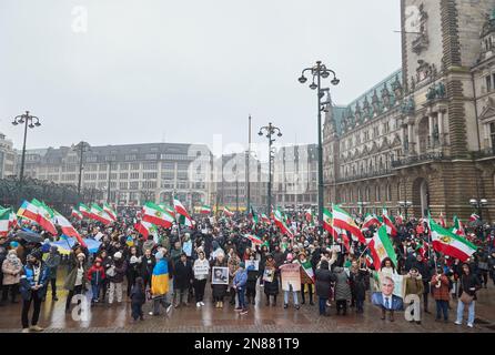 Amburgo, Germania. 11th Feb, 2023. I partecipanti a una manifestazione contro il regime iraniano detengono bandiere iraniane al Rathausmarkt. L'Unione iraniana aveva chiesto la manifestazione. Sotto lo slogan "sostegno e solidarietà al popolo iraniano - protesta contro il regime iraniano”, i partecipanti hanno marciato da Mönckebergstraße al Rathausmarkt. Credit: Georg Wendt/dpa/Alamy Live News Foto Stock