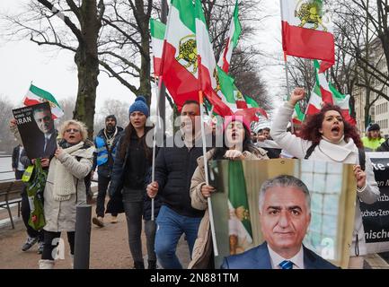 Amburgo, Germania. 11th Feb, 2023. I partecipanti a una manifestazione contro il regime iraniano detengono bandiere iraniane e una foto del persiano Shah Mohammad Reza Pahlavi, rovesciato nel 1979, sul Ballindamm. L'Unione iraniana aveva chiesto la manifestazione. Sotto lo slogan "sostegno e solidarietà al popolo iraniano - protesta contro il regime iraniano”, i partecipanti si sono trasferiti da Mönckebergstraße al Rathausmarkt. Credit: Georg Wendt/dpa/Alamy Live News Foto Stock