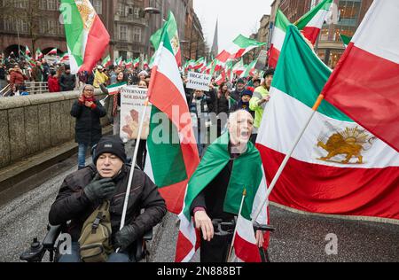 Amburgo, Germania. 11th Feb, 2023. I partecipanti a una manifestazione contro il regime iraniano detengono bandiere iraniane su Mönckebergstraße. L'Unione iraniana aveva chiesto la manifestazione. Sotto lo slogan "sostegno e solidarietà al popolo iraniano - protesta contro il regime iraniano”, i partecipanti si sono trasferiti da Mönckebergstraße al Rathausmarkt. Credit: Georg Wendt/dpa/Alamy Live News Foto Stock