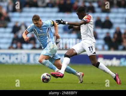 Callum Doyle di Coventry City (a sinistra) e Elijah Adebayo di Luton Town si battono per la palla durante la partita del campionato Sky Bet presso la Coventry Building Society Arena di Coventry. Data immagine: Sabato 11 febbraio 2023. Foto Stock