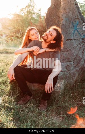 Hipster, coppia romantica divertirsi nel parco. Godendo il sole di pomeriggio. Ragazzo capelli ricci con ragazza dai capelli lunghi. Foto Stock