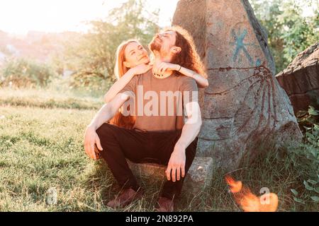 Hipster, coppia romantica divertirsi nel parco. Godendo il sole di pomeriggio. Ragazzo capelli ricci con ragazza dai capelli lunghi. Foto Stock