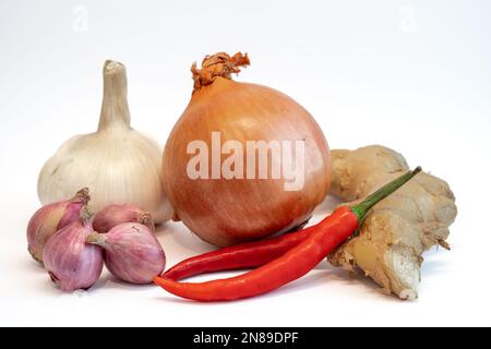 Peperoncino, cipolla, scalogno, zenzero e aglio isolati su sfondo bianco. Ingrediente importante utilizzato nella cucina asiatica per fornire aroma e sapore. Foto Stock