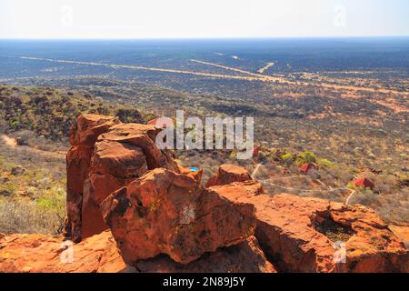 Tetti rossi del Waterberg Plateau Lodge in Namibia si annidano in alto sul pendio di Waterberg con vista attraverso l'infinito Kalahari. Namibia. Foto Stock