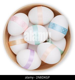 Buone decorazioni pasquali, cesto pieno di uova pasquali con nastro in colori pastello chiari, vista dall'alto su sfondo bianco. Modello per etichetta, regalo greeti Foto Stock