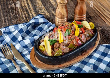 Arrosto di carne saltato con verdure su sfondo di legno.Saute carne in casseruola. Carne Saute Turco e sote, cucina turca. Nome turco; et Sote. Foto Stock