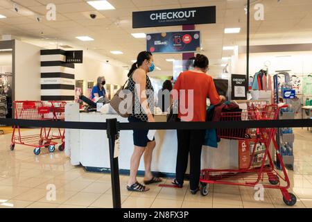 Due donne asiatiche fanno il check-out in una stazione all'interno di JC Penny a Wichita, Kansas, USA, durante la pandemia del 2020. Foto Stock