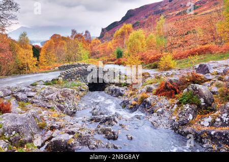 Steely Grays, con le sue tonalità autunnali bruciate, ha ambientato la scena nella pittoresca località di Ashness Bridge, attraversando Barrow Beck, Lake District National Park, Regno Unito Foto Stock