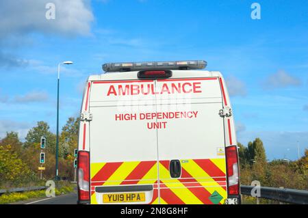 Un furgone di ambulanza bianco dell'unità di dipendenza alta che guida su un'autostrada britannica Foto Stock