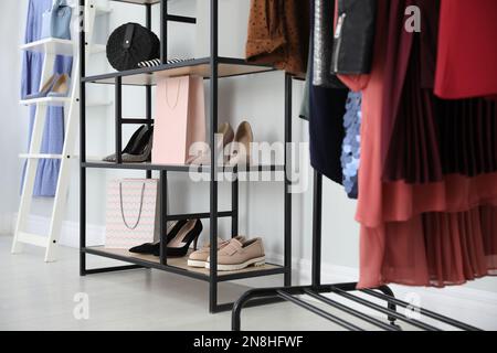 Scaffalatura con abiti, scarpe e borsa in camera da letto leggera Foto stock  - Alamy