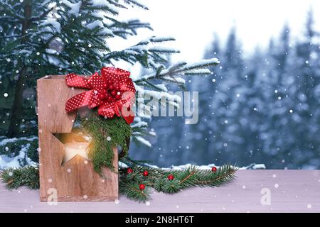 Lanterna di Natale in legno con candela bruciante all'aperto. Spazio per il testo Foto Stock