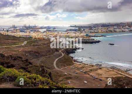 Panorama di Las Palomas con navi nel porto dalla vicina collina nelle giornate nuvolose. Onde oceaniche che colpiscono le rocce sulla spiaggia. Foto Stock