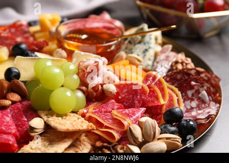 Piatto di antipasti diversi con miele sul tavolo, primo piano Foto Stock