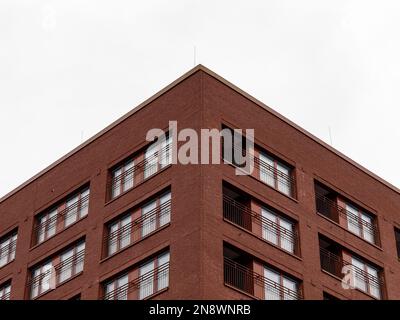 Angolo di una casa. Facciata moderna di un edificio residenziale in una città. Esterno con finestre e clinker mattoni rossi. Foto Stock