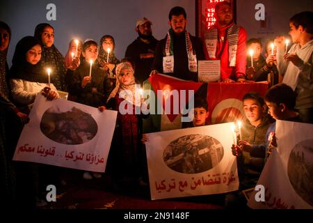 Jabalia, striscia di Gaza, Palestina. 11th Feb, 2023. Gaza, Palestina. 11 febbraio 2023. I bambini palestinesi tengono una veglia a Jabalia per le vittime dei terremoti di Turkiye e della Siria. Un terremoto di magnitudo 7,8 ha colpito il sud di Turkiye e la Siria nord-occidentale lunedì, seguito da un tremore di magnitudo 7,6 e da diverse scosse di assestamento. Entrambi i paesi sono stati devastati dalle massicce scosse, con oltre 25.000 persone uccise e migliaia di feriti, oltre alla distruzione di migliaia di edifici in mezzo a temperature di congelamento (Credit Image: © Ahmad Hasaballah/IMAGESLIVE via ZUMA Press Wire) EDITORE Foto Stock