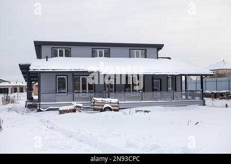 Cottage in legno nella stagione invernale, cortile coperto di neve, nessuno Foto Stock