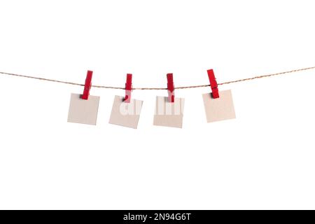 Set di quattro fogli di carta bianca note tenuto su una stringa con clothespins isolati su sfondo bianco Foto Stock