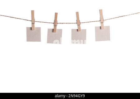 Set di quattro fogli di carta bianca note tenuto su una stringa con clothespins isolati su sfondo bianco Foto Stock